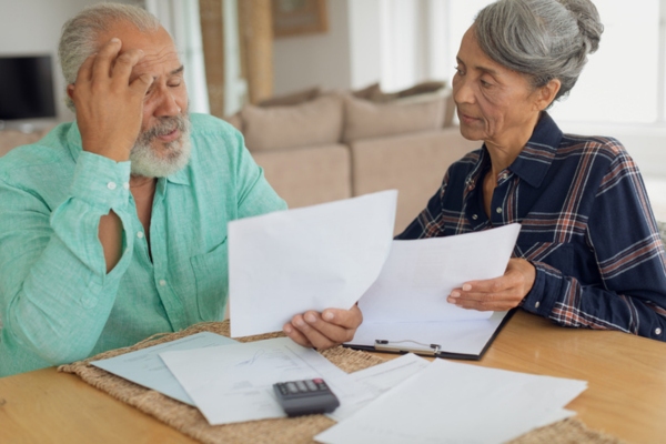 couple computing bills at home depicting heating oil requirements