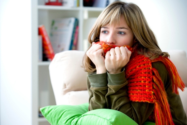 woman feeling cold indoors due to oil-fired heating system shutdown