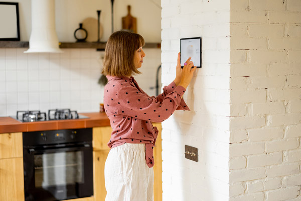 woman using smart hvac thermostat for managing energy costs