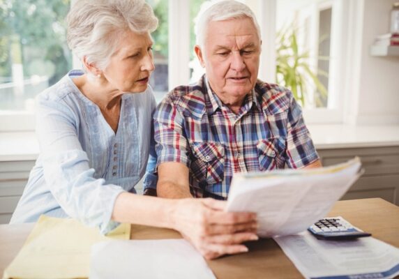 senior couple looking at and discussing energy bill depicting ways to reduce heating bills